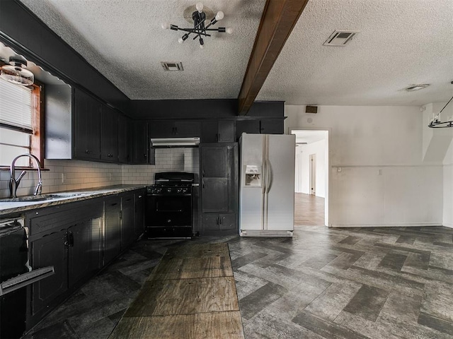 kitchen featuring beam ceiling, white fridge with ice dispenser, sink, tasteful backsplash, and black gas stove