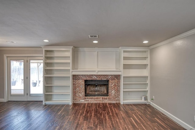 unfurnished living room with baseboards, visible vents, dark wood-style floors, ornamental molding, and a brick fireplace