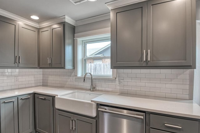 kitchen with light stone counters, a sink, stainless steel dishwasher, backsplash, and gray cabinets