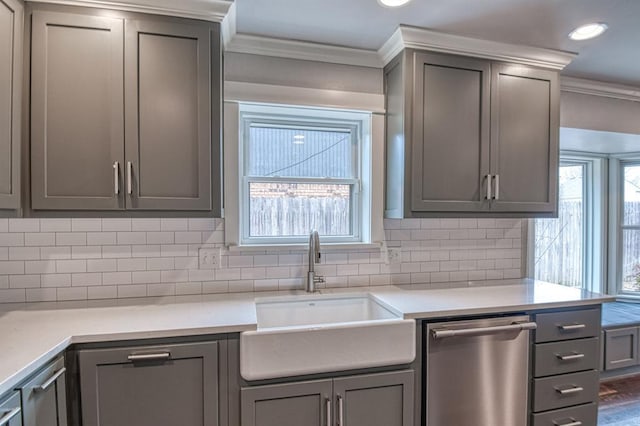 kitchen with dishwasher, light countertops, a sink, and gray cabinetry