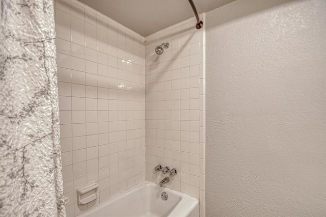 full bathroom with shower / bath combo with shower curtain and a textured wall