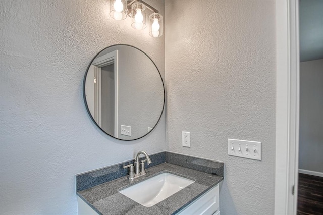 bathroom with a textured wall and vanity