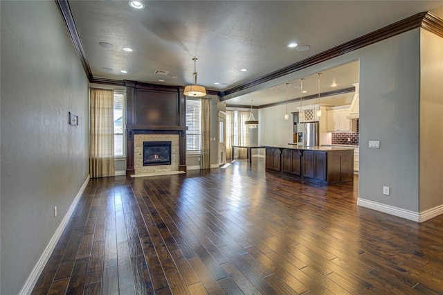 unfurnished living room featuring a fireplace, dark hardwood / wood-style floors, and ornamental molding