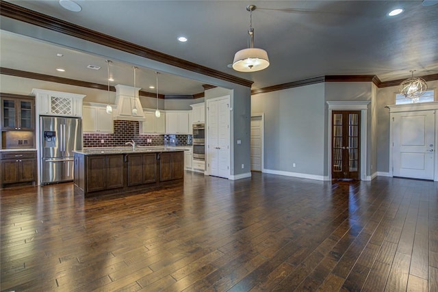 kitchen featuring a center island with sink, dark hardwood / wood-style floors, decorative light fixtures, and appliances with stainless steel finishes