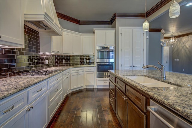 kitchen featuring appliances with stainless steel finishes, crown molding, white cabinets, dark hardwood / wood-style floors, and hanging light fixtures