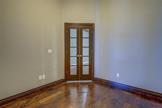 empty room featuring french doors and dark wood-type flooring