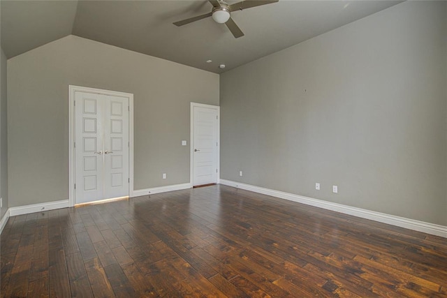 empty room with ceiling fan, dark hardwood / wood-style flooring, and lofted ceiling