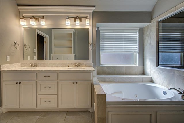 bathroom with a washtub, vanity, and tile patterned floors