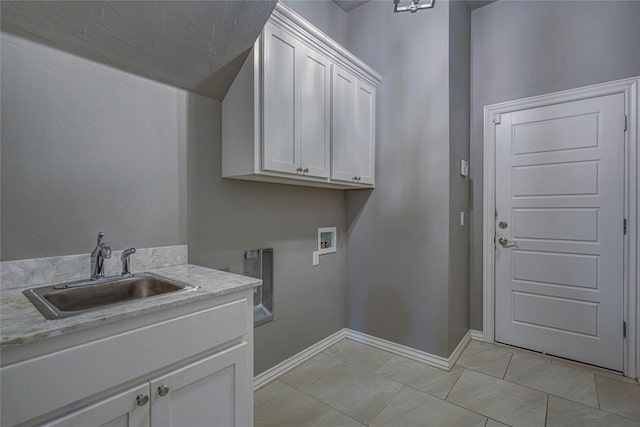 laundry room featuring hookup for a washing machine, sink, light tile patterned floors, and cabinets