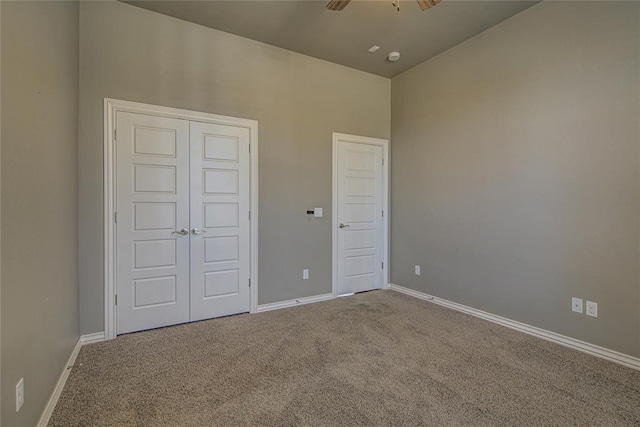 unfurnished bedroom featuring ceiling fan, a closet, and carpet