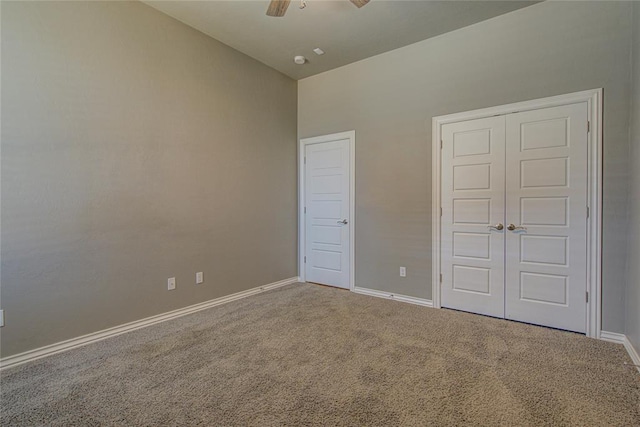 unfurnished bedroom with carpet, a closet, and ceiling fan