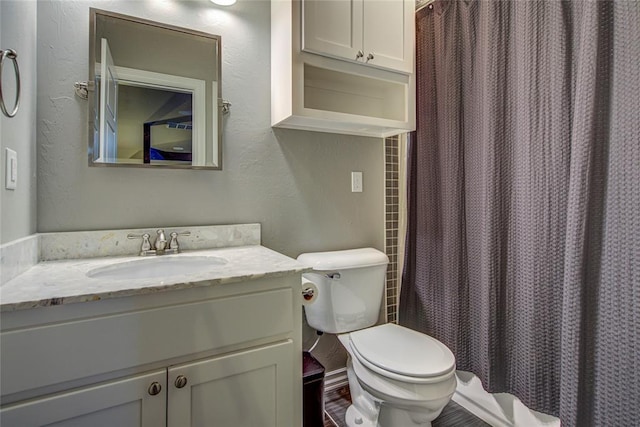 bathroom with a shower with shower curtain, vanity, and toilet