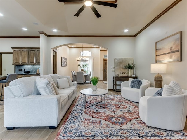 living room featuring crown molding, light hardwood / wood-style flooring, and ceiling fan