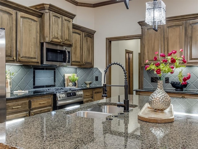 kitchen featuring appliances with stainless steel finishes, sink, dark stone countertops, and decorative backsplash