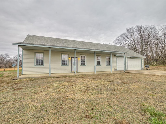 ranch-style house featuring a garage, covered porch, and a front lawn