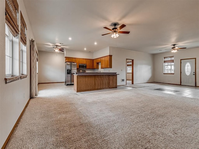 unfurnished living room featuring ceiling fan and light colored carpet