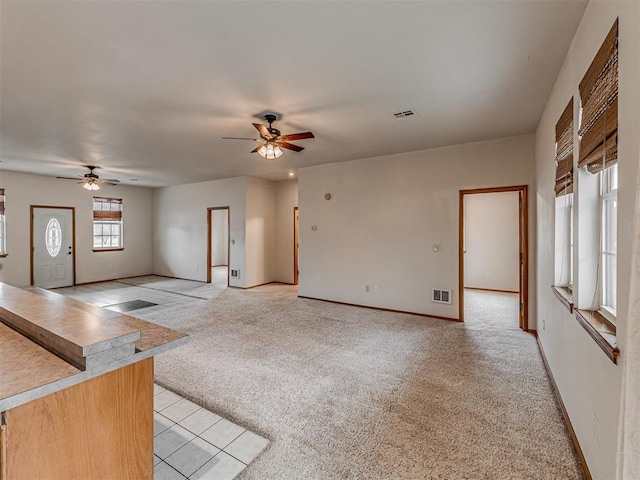 unfurnished living room with ceiling fan and light carpet