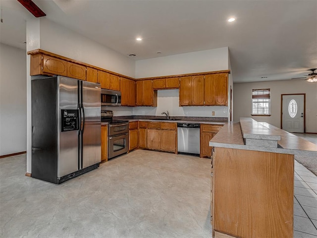 kitchen featuring ceiling fan, sink, and stainless steel appliances