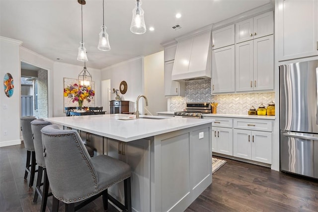 kitchen featuring stainless steel appliances, sink, a kitchen island with sink, and custom exhaust hood