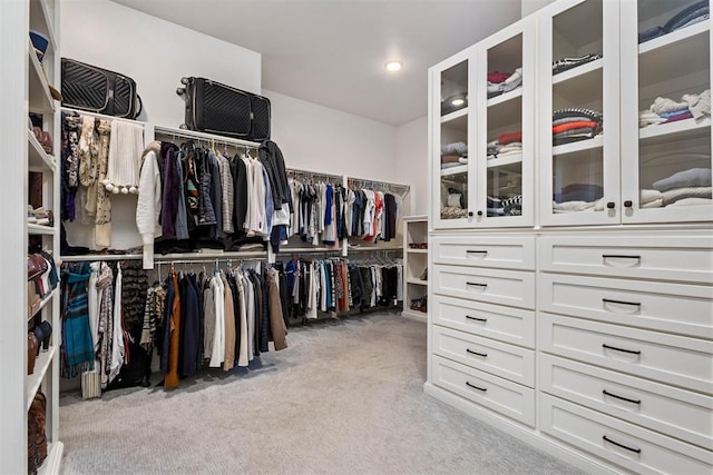 spacious closet featuring light colored carpet