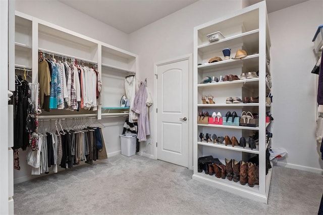 walk in closet featuring light carpet