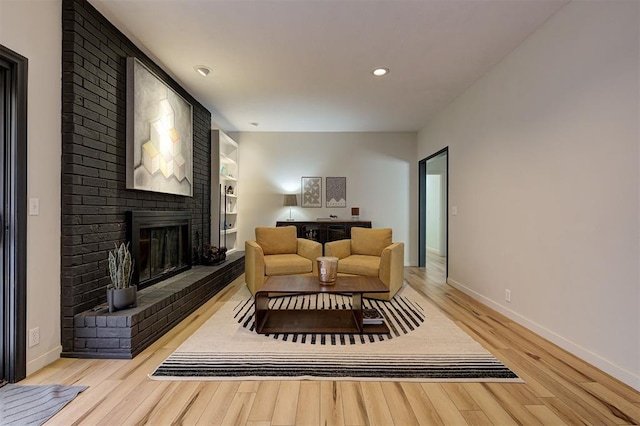 sitting room with light hardwood / wood-style flooring and a brick fireplace