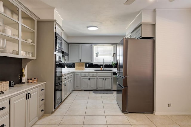 kitchen featuring gray cabinetry, light tile patterned floors, sink, and stainless steel refrigerator