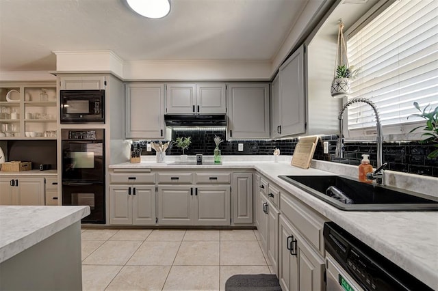 kitchen with gray cabinetry, sink, backsplash, light tile patterned floors, and black appliances