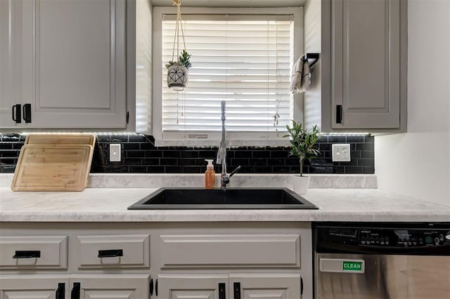 kitchen featuring backsplash, dishwasher, a healthy amount of sunlight, and sink