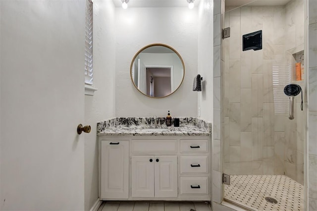 bathroom featuring vanity and a shower with door