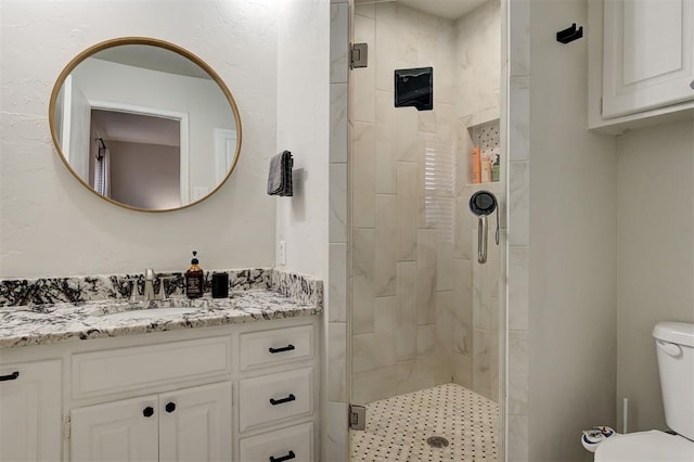 bathroom featuring walk in shower, vanity, and toilet