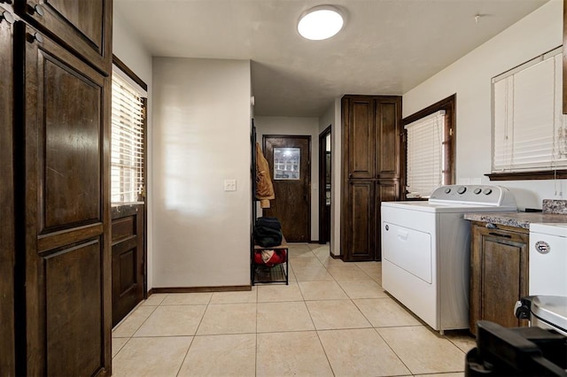 laundry room featuring cabinets, washer / dryer, and light tile patterned floors