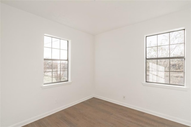 spare room with dark hardwood / wood-style floors and a healthy amount of sunlight