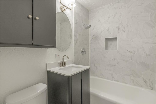 full bathroom featuring vanity, toilet, a textured ceiling, and tiled shower / bath