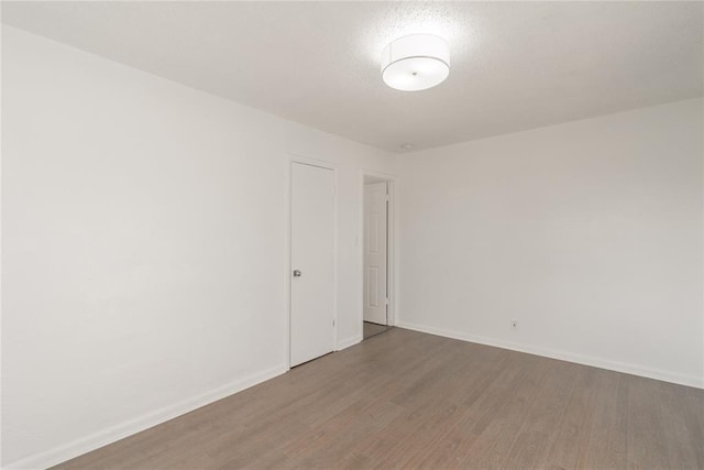 spare room featuring a textured ceiling and hardwood / wood-style flooring