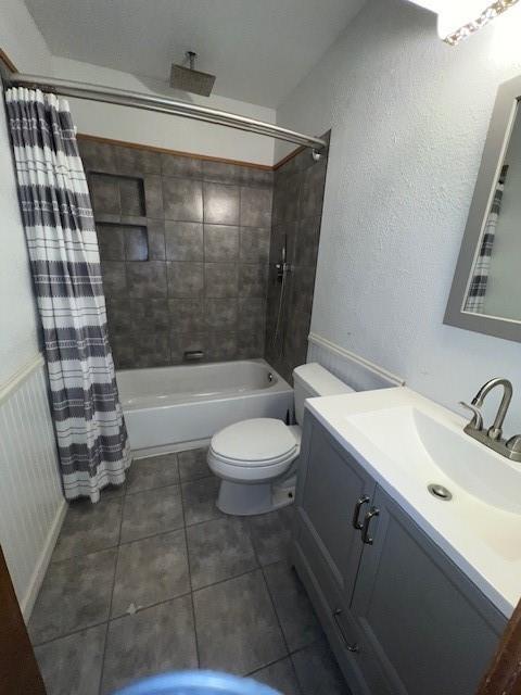 full bathroom featuring tile patterned floors, vanity, toilet, and shower / bathtub combination with curtain