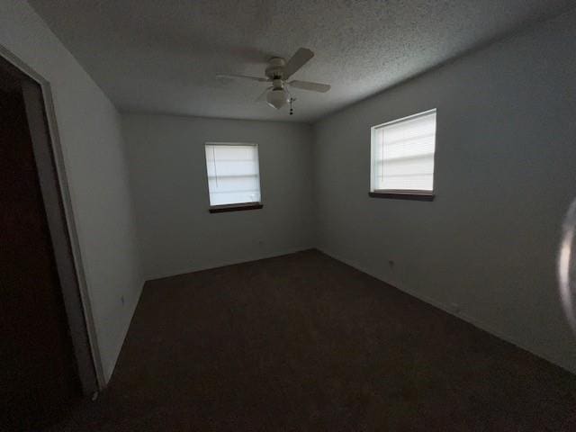 unfurnished room featuring a textured ceiling, plenty of natural light, and ceiling fan