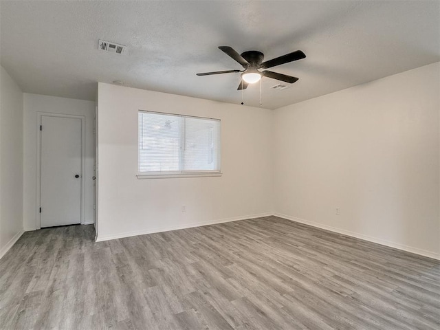 empty room featuring ceiling fan, a textured ceiling, and light hardwood / wood-style flooring