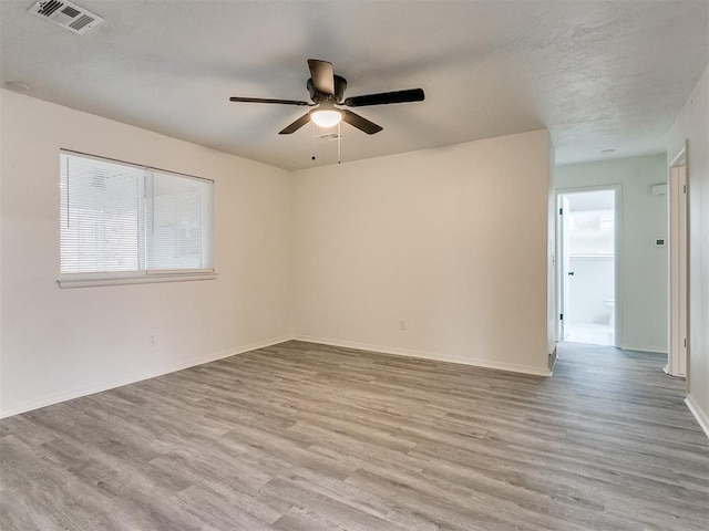 empty room featuring ceiling fan and light hardwood / wood-style floors