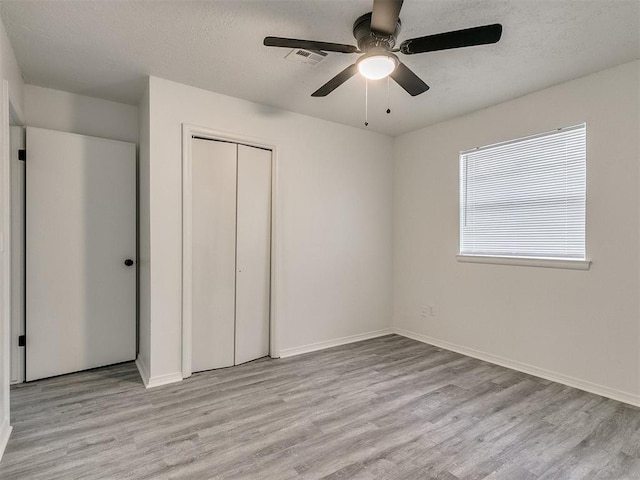 unfurnished bedroom featuring ceiling fan, a closet, and light hardwood / wood-style floors