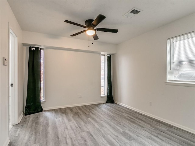 spare room with a wealth of natural light, light hardwood / wood-style flooring, and ceiling fan