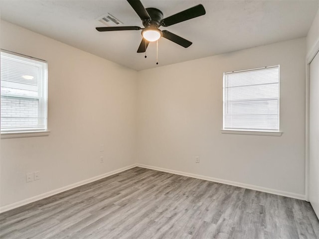 spare room with ceiling fan and light wood-type flooring