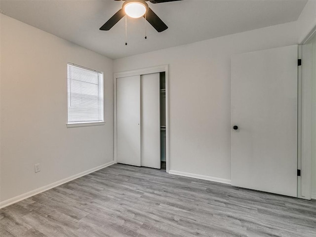 unfurnished bedroom with ceiling fan, light hardwood / wood-style flooring, and a closet