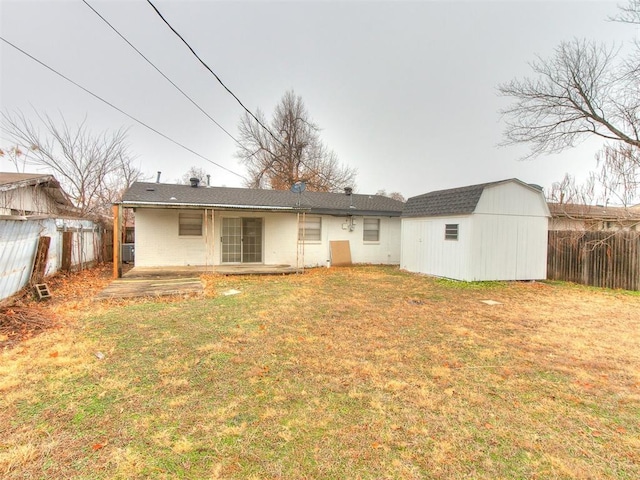 rear view of property with a yard and a shed