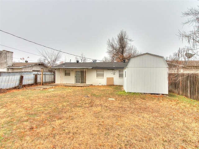 rear view of house with a yard and a storage shed