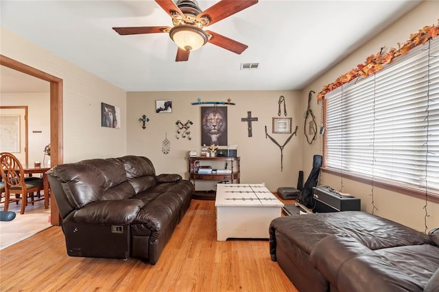 living room with light hardwood / wood-style flooring and ceiling fan