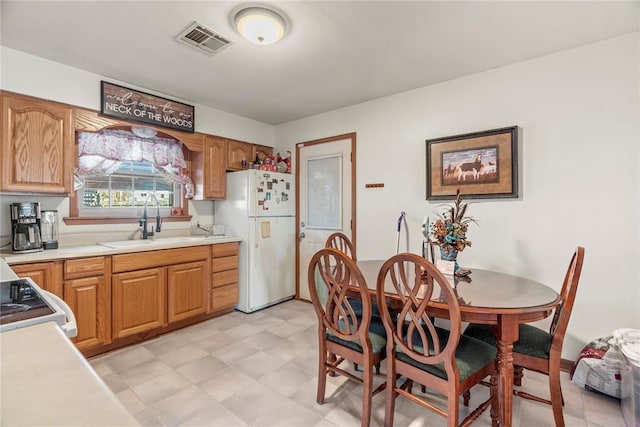 kitchen featuring sink, white fridge, and range