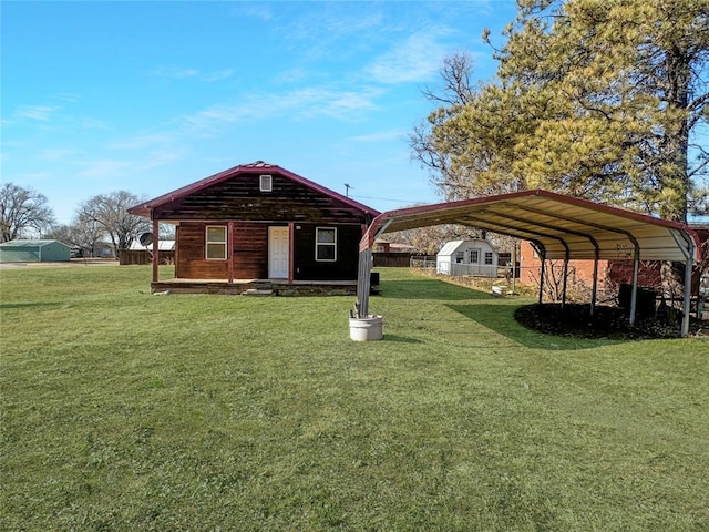 view of front facade with a carport, a front lawn, and a storage shed