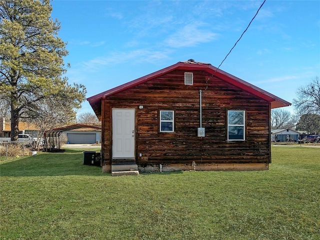 rear view of house featuring a lawn and cooling unit