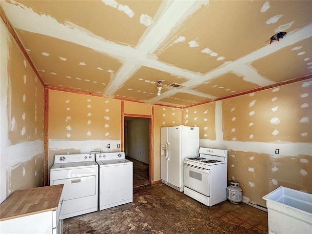 kitchen with independent washer and dryer, white appliances, and sink